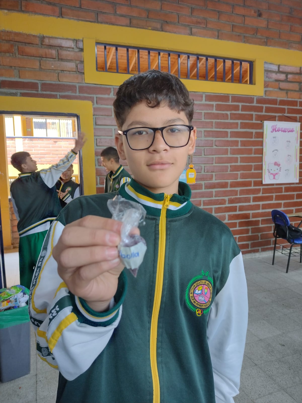 Estudiante mostrando empaque rotulado de semillas de cebolla