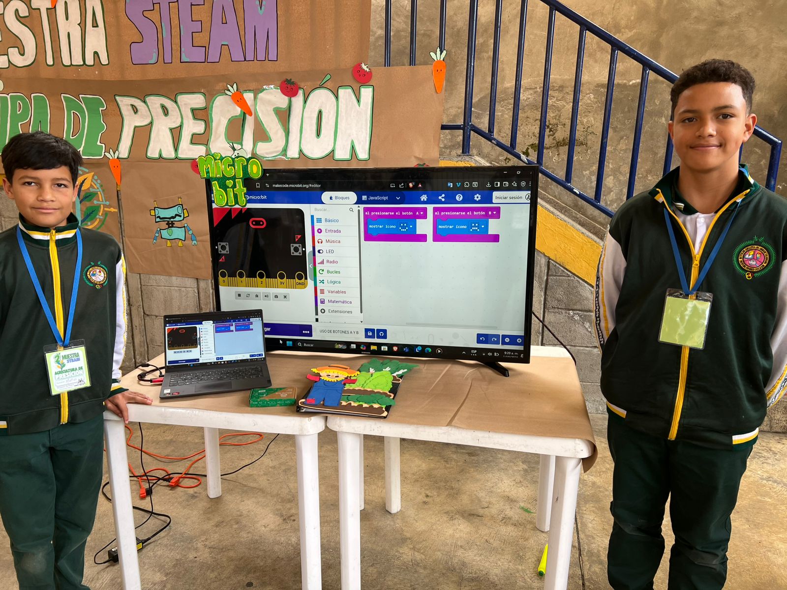 Estudiantes en el stand interactivo demostrando programación MakeCode micro:bit