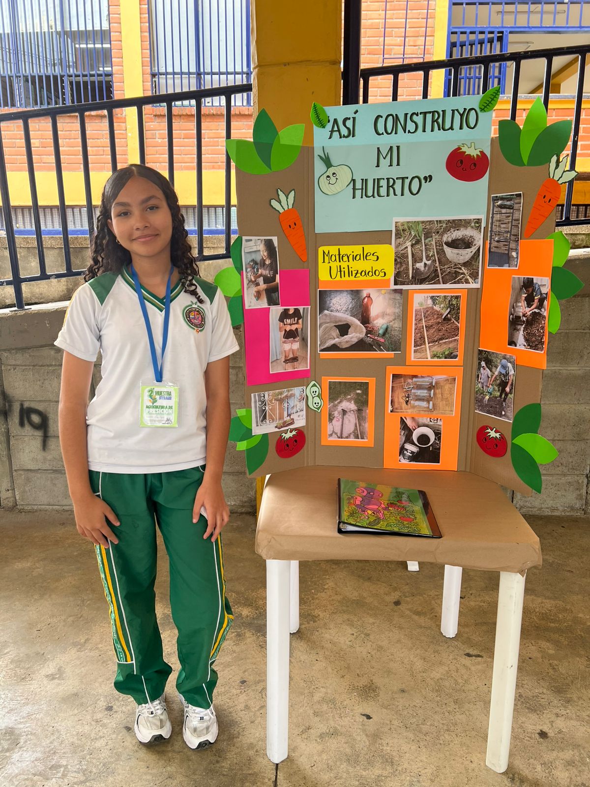 Estudiante exponiendo el póster informativo Así Construyo Mi Huerto